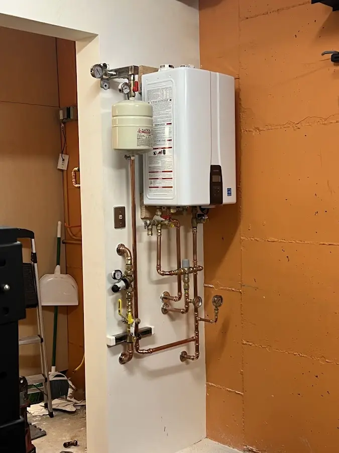 Plumbing technician inspecting water heater connections in Unicoi
